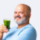 Indian Asian elderly old senior man drinking an organic green smoothie or juice in a glass