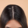 Woman with dandruff in her dark hair on beige background, closeup